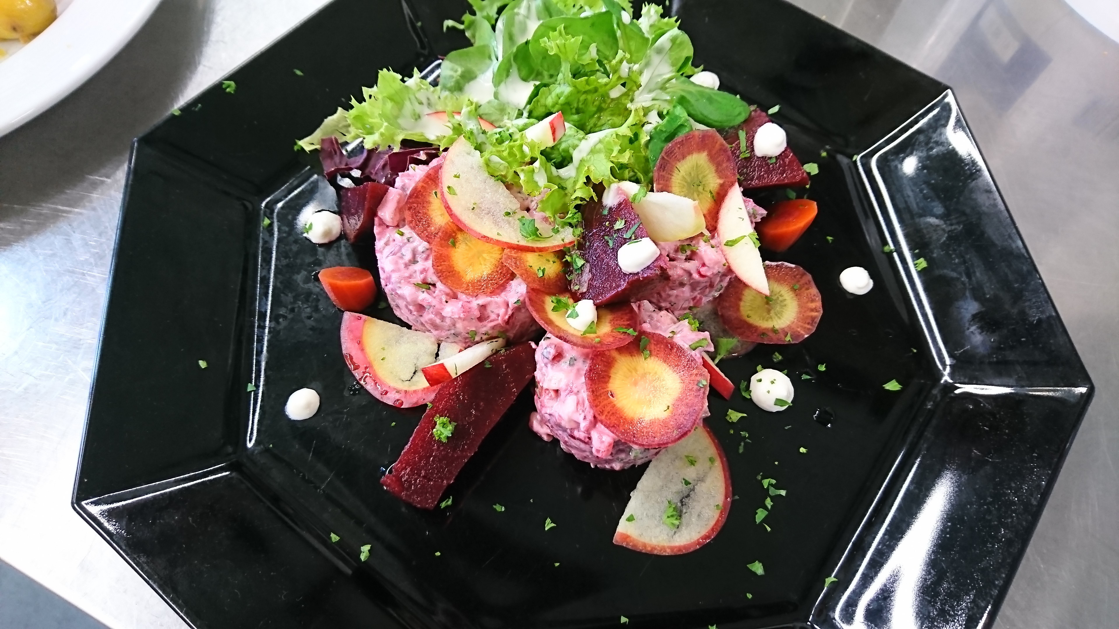 Matjes Tatar mit roter Beete, dazu Meerrettich, Apfel, kleines Salatbouquet und Baguette